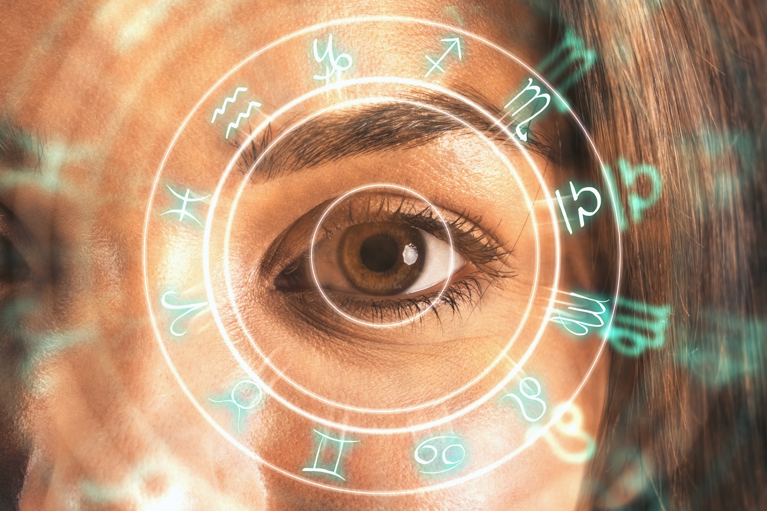 A close-up studio shot reveals an eye surrounded by glowing zodiac symbols. Symbolizing knowledge of birth chart Jyotish and remedies application to the modern lifestyle.
