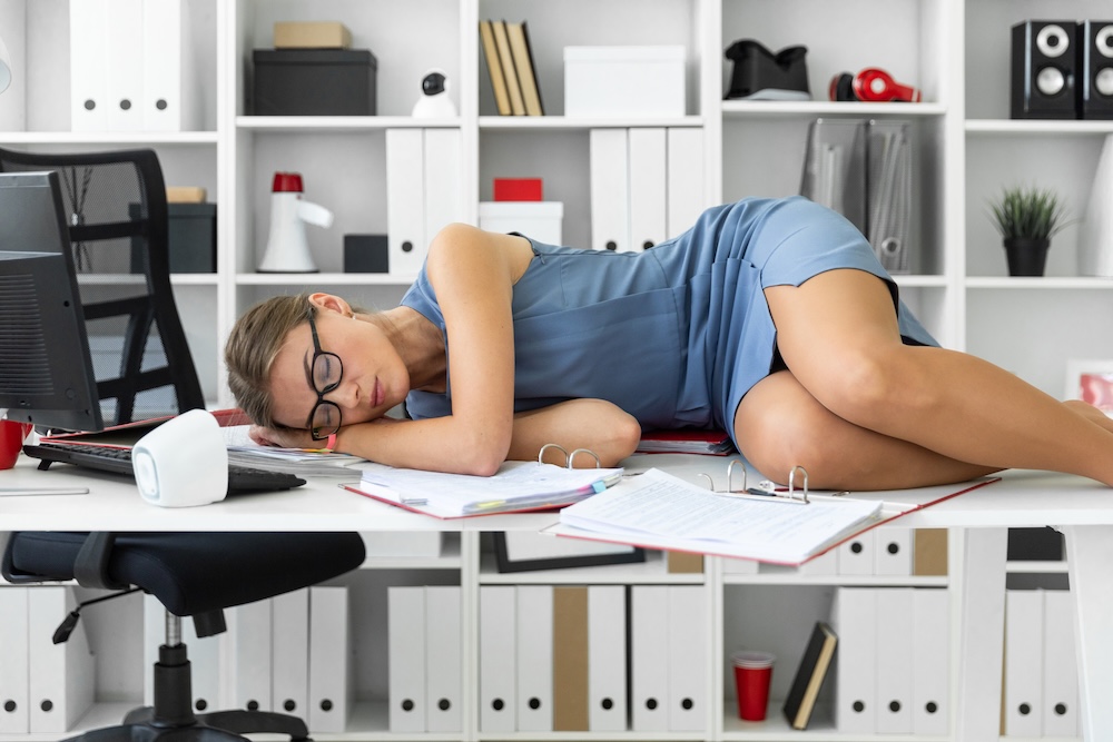 Beautiful young girl in a blue dress is tired of work in the office. Concept of wellness and work-life balance, mindful living, vedic sciences and ayurveda for harmony in life and work.